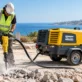 Atlas Copco diesel air compressor running a jackhammer on a construction site in Cyprus